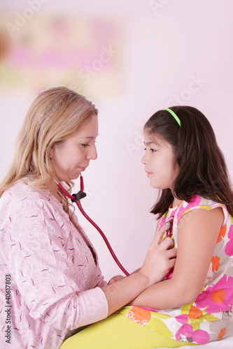 Female doctor examining little girl