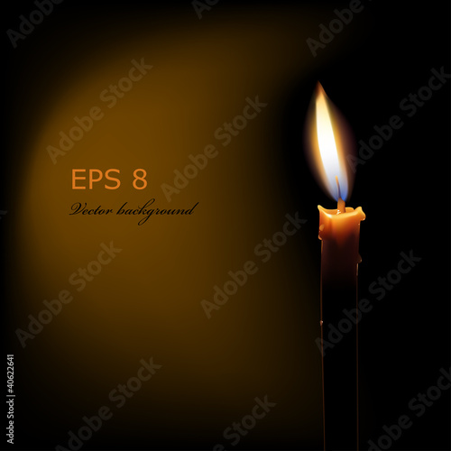 burning candle on black background
