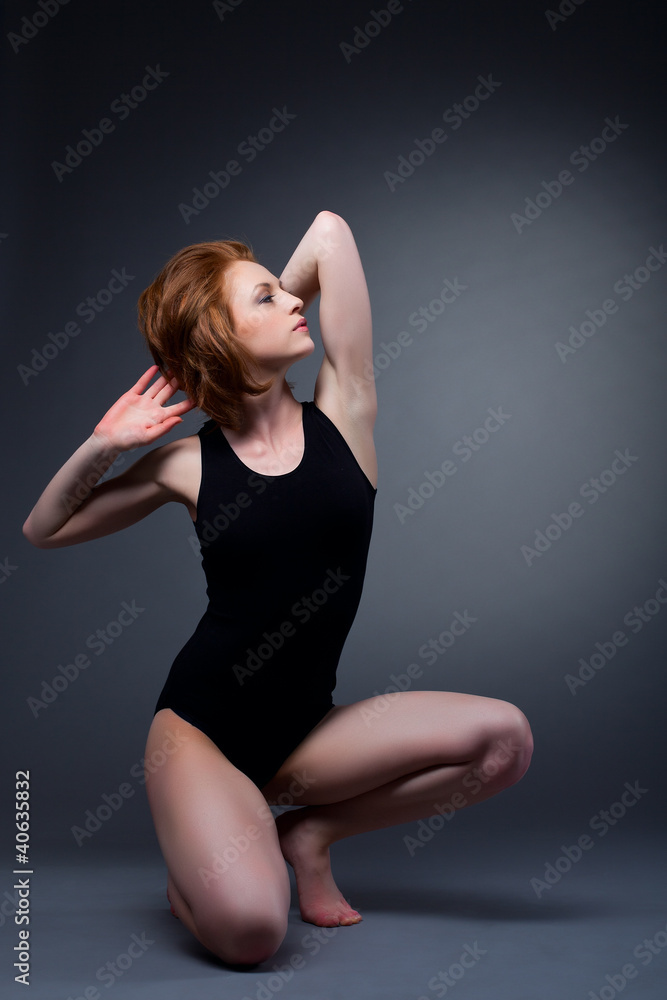 Athletic sexy girl posing on dark background