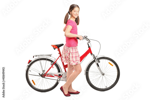 Fototapeta Naklejka Na Ścianę i Meble -  Full length portrait a girl holding a bike