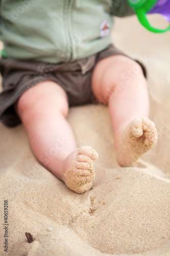Baby feet covered in beach sand