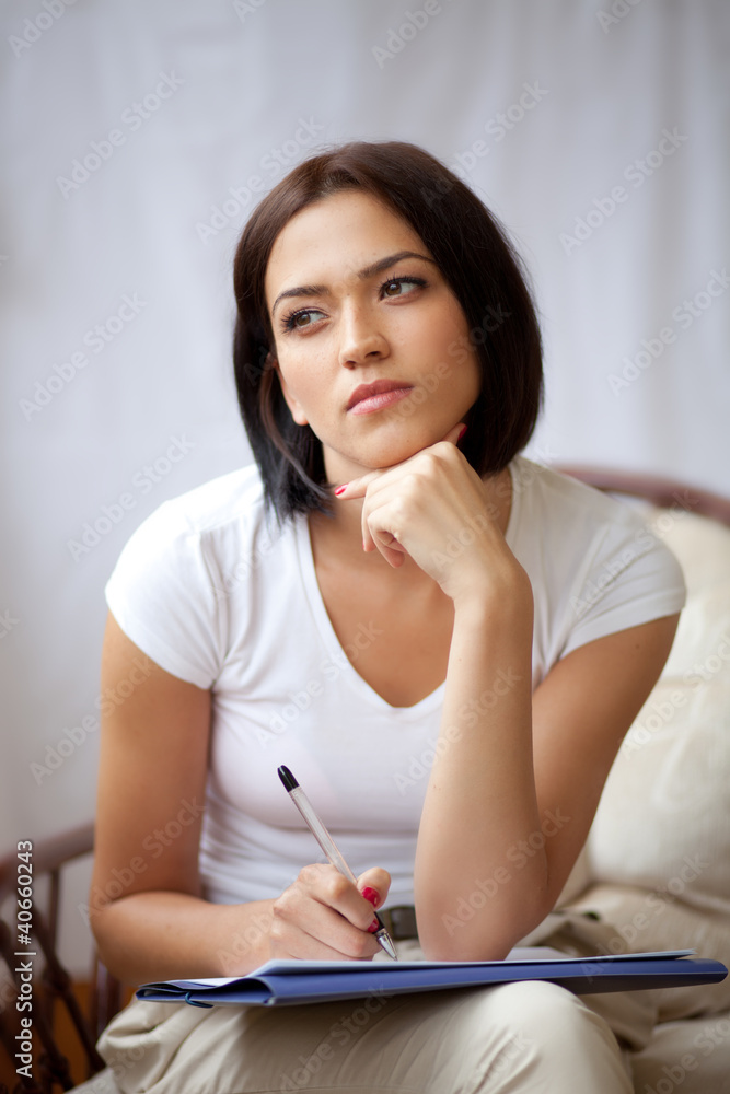 Obraz premium Woman writing on notepad to do list at home