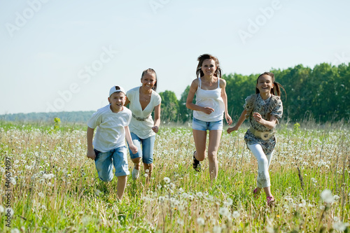 women with teens running in grass