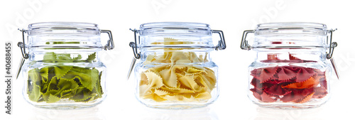 Jars of coloured pasta isolated on white