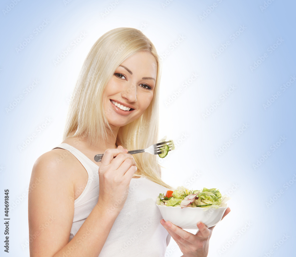A young blond woman holding a fresh green salad A young blond woman holding a fresh green salad