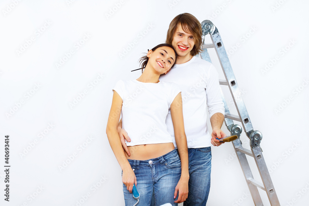 Young couple with paint brushes together Young couple with paint brushes together
