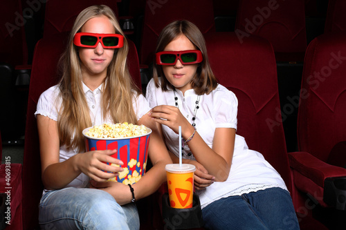 Two young girls watching in cinema