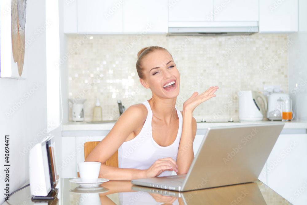 Laughing woman sitting at laptop computer Laughing woman sitting at laptop computer