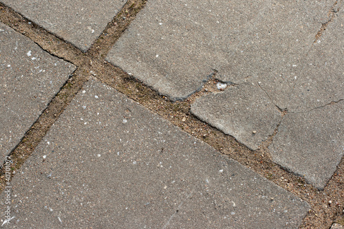 Grey square tiles of pavement forming