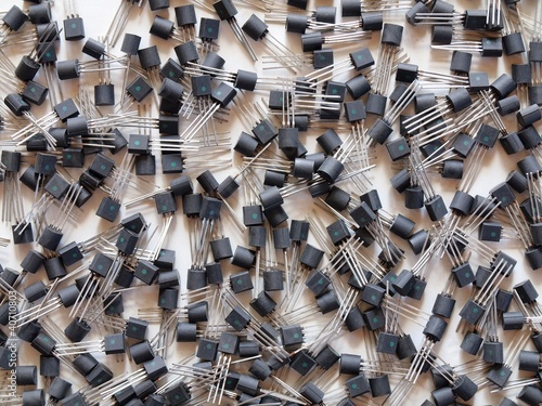 Background with components of electronics - black transistors photo