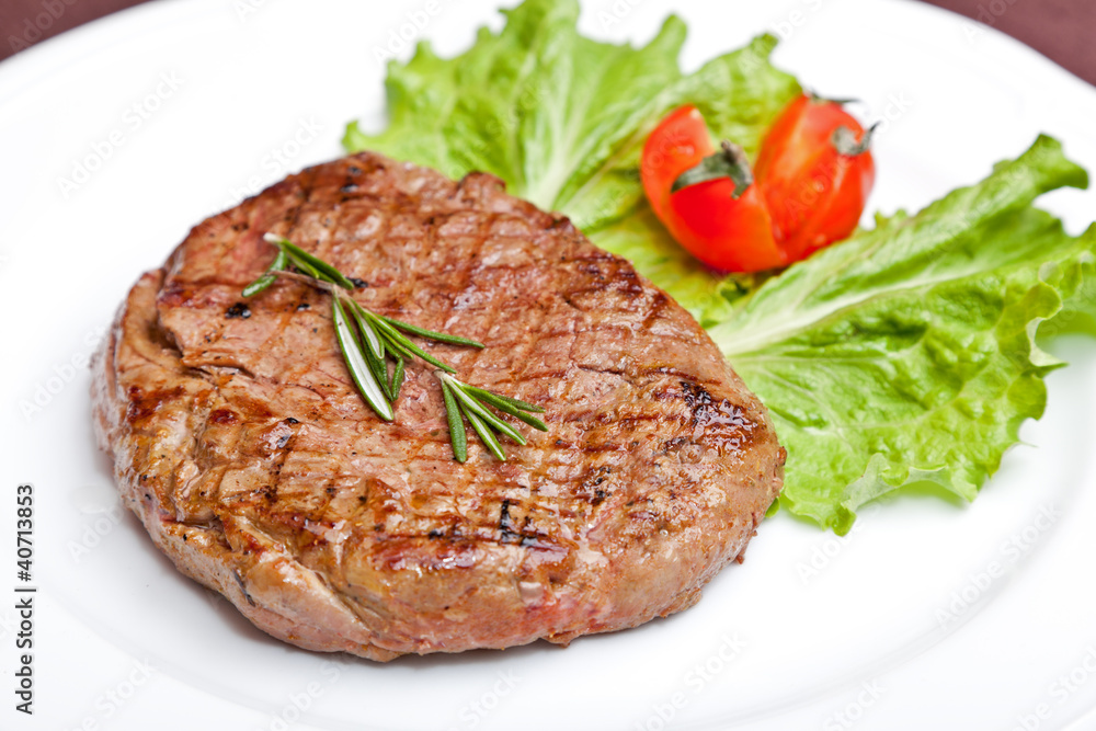 Grilled steak on a white plate