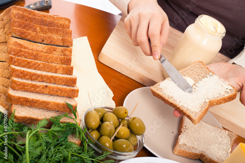 Spreading mayonnaise on sandwich