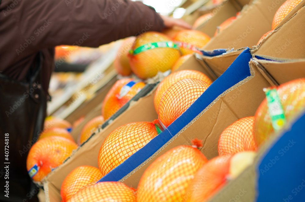 Orange pomelos in boxes in supermarket