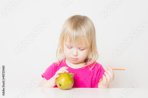 Adorable baby suck juice from pear with straw