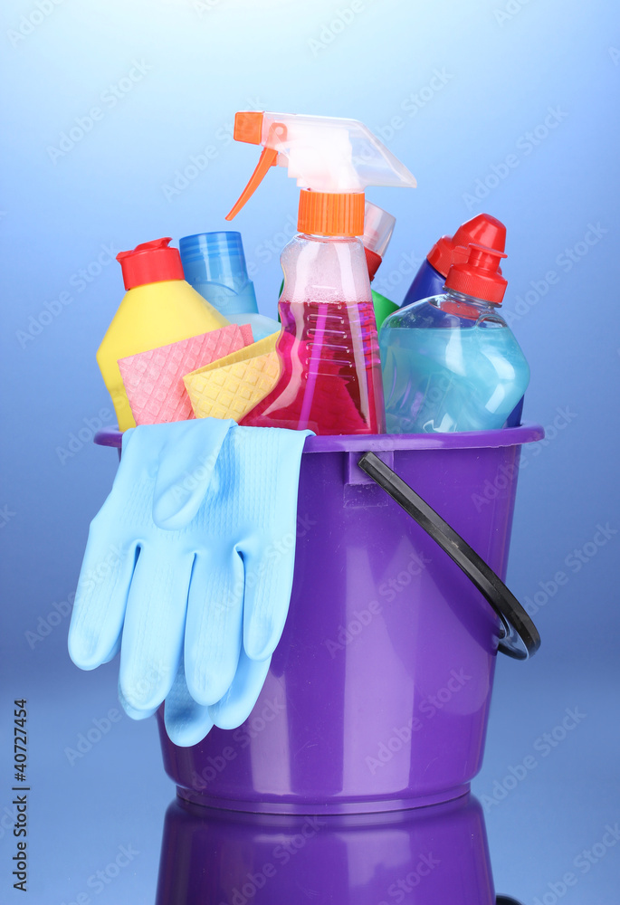 Bucket with cleaning items on blue background Bucket with cleaning items on blue background