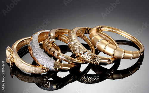 Beautiful golden bracelets on grey background photo