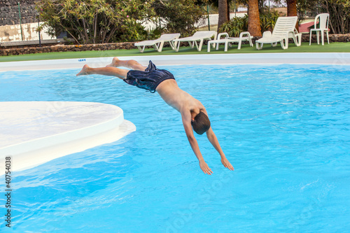 boy jumping in the blue pool