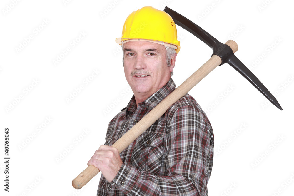 Mature laborer carrying a pickaxe on his shoulder Mature laborer carrying a pickaxe on his shoulder