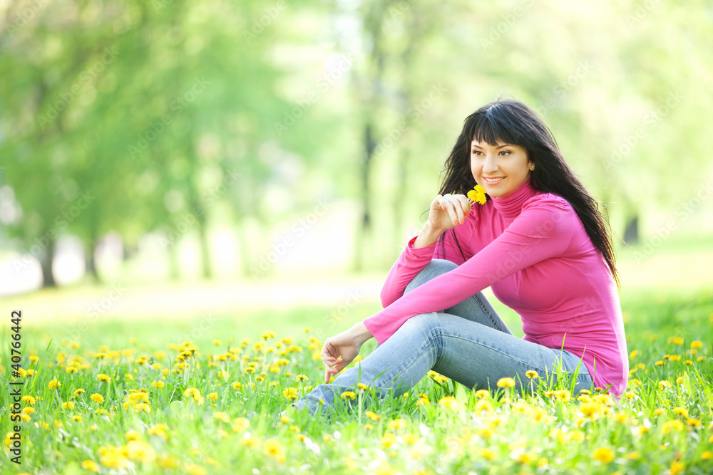 Cute woman in the park with dandelions Cute woman in the park with dandelions