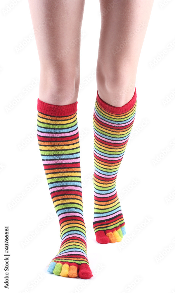female legs in colorful striped socks isolated on white female legs in colorful striped socks isolated on white