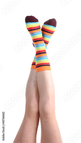 female legs in colorful striped socks isolated on white