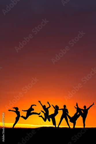 silhouette of friends dancing in sunset