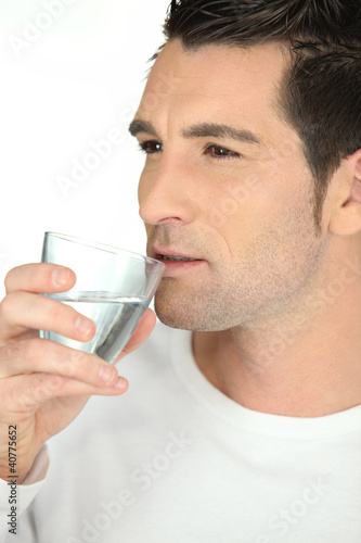 bust shot of man drinking glass of water