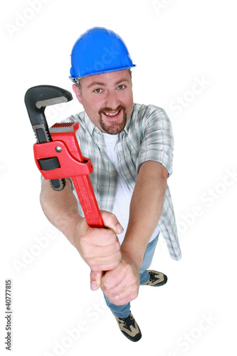 Chubby plumber holding adjustable wrench