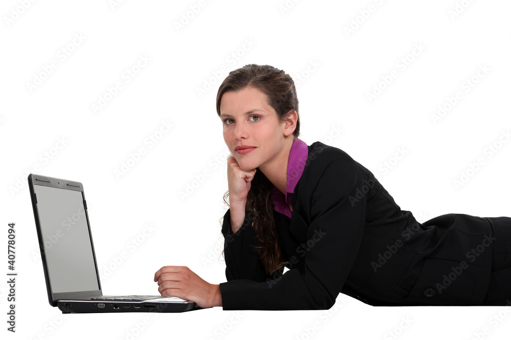 Businesswoman lying down with a laptop Businesswoman lying down with a laptop