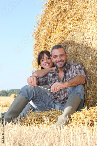 Принти на полотні Farmer and wife sat on hay bale