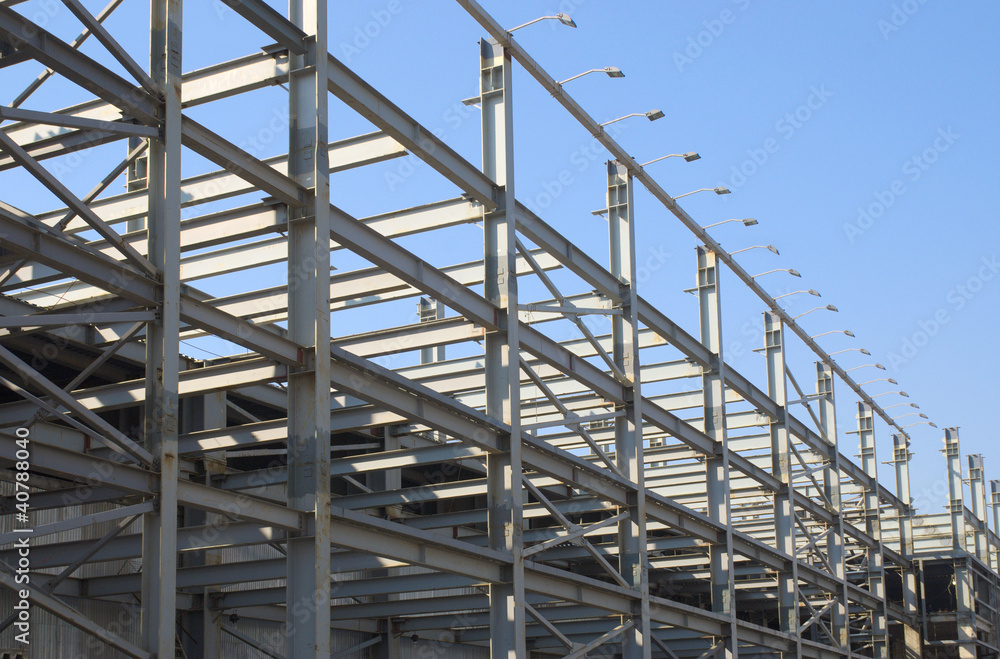Gray Industrial house construction frames over clear blue sky Gray Industrial house construction frames over clear blue sky