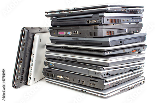 Pile of used laptops, white background