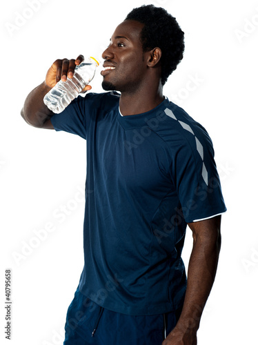 Tired african athlete drinking water