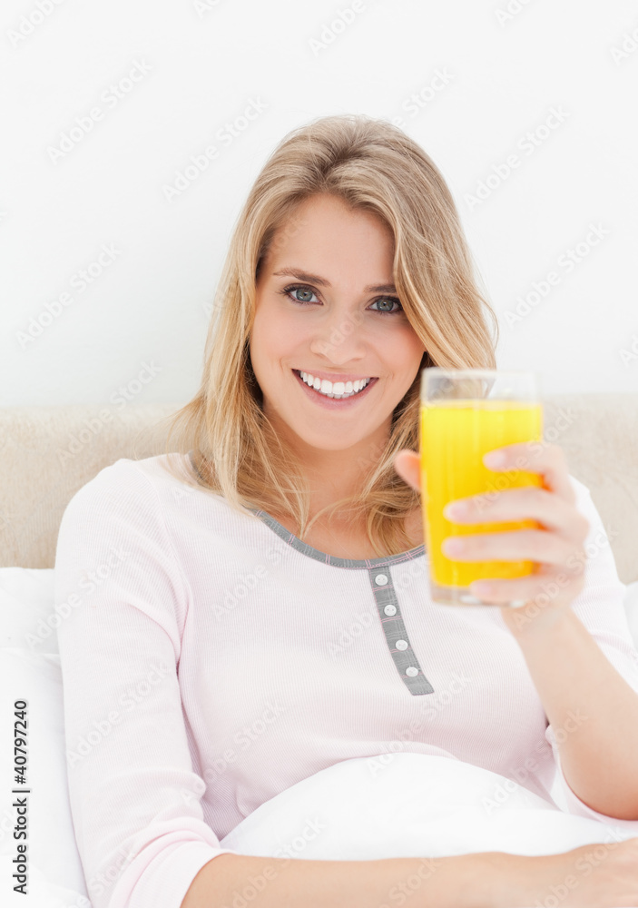 Close up, Woman looking forward smiling while holding up a glass Close up, Woman looking forward smiling while holding up a glass