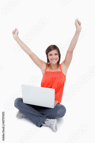 Attractive young woman sitting cross-legged and raised arms © WavebreakmediaMicro