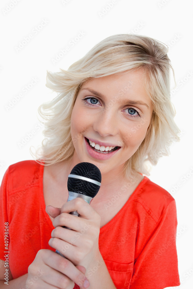 Smiling teenager singing in a cordless microphone Smiling teenager singing in a cordless microphone