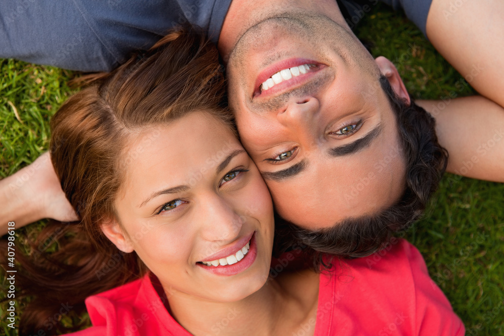 Close-up of two friends looking upwards while lying head to shou Close-up of two friends looking upwards while lying head to shou