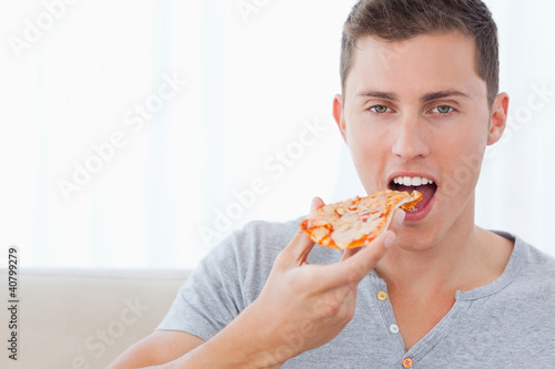 A man about to take a bite out of his pizza