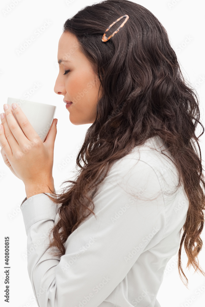 Profile of a brunette smelling a hot coffee