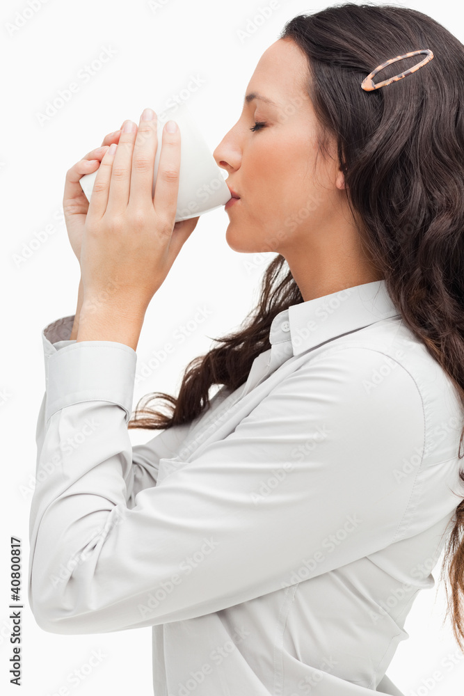 Profile of a brunette drinking a hot coffee Profile of a brunette drinking a hot coffee