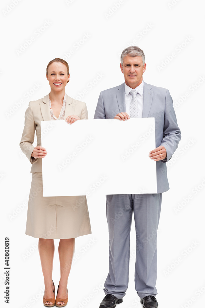 Business people smiling while holding a poster Business people smiling while holding a poster
