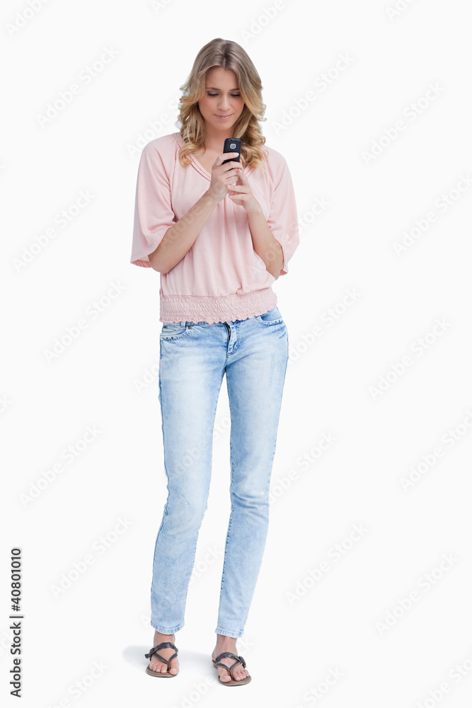A woman standing holding her mobile phone A woman standing holding her mobile phone