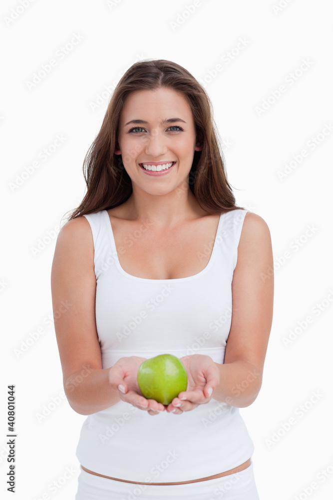 Smiling woman looking at the camera while holding an apple Smiling woman looking at the camera while holding an apple