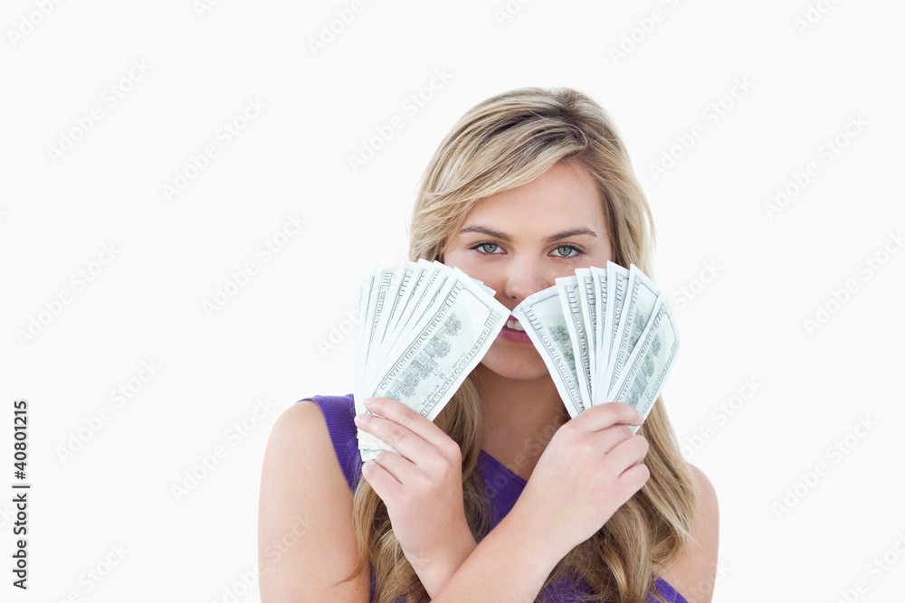 Young blonde woman holding two fans of notes Young blonde woman holding two fans of notes