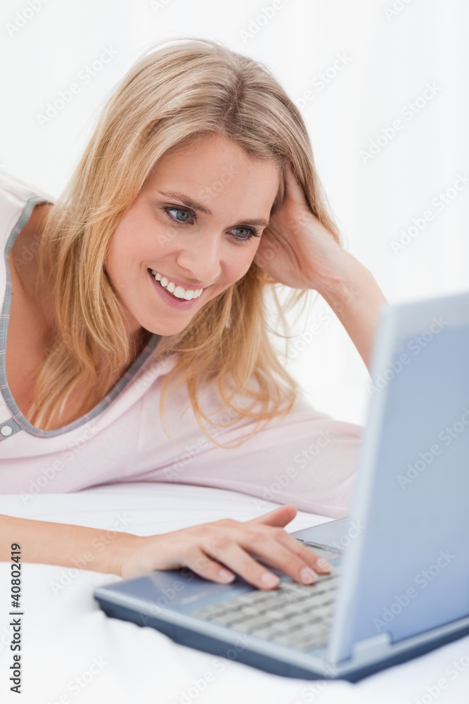 Close up, Woman using her laptop, looking at the screen and smil Close up, Woman using her laptop, looking at the screen and smil