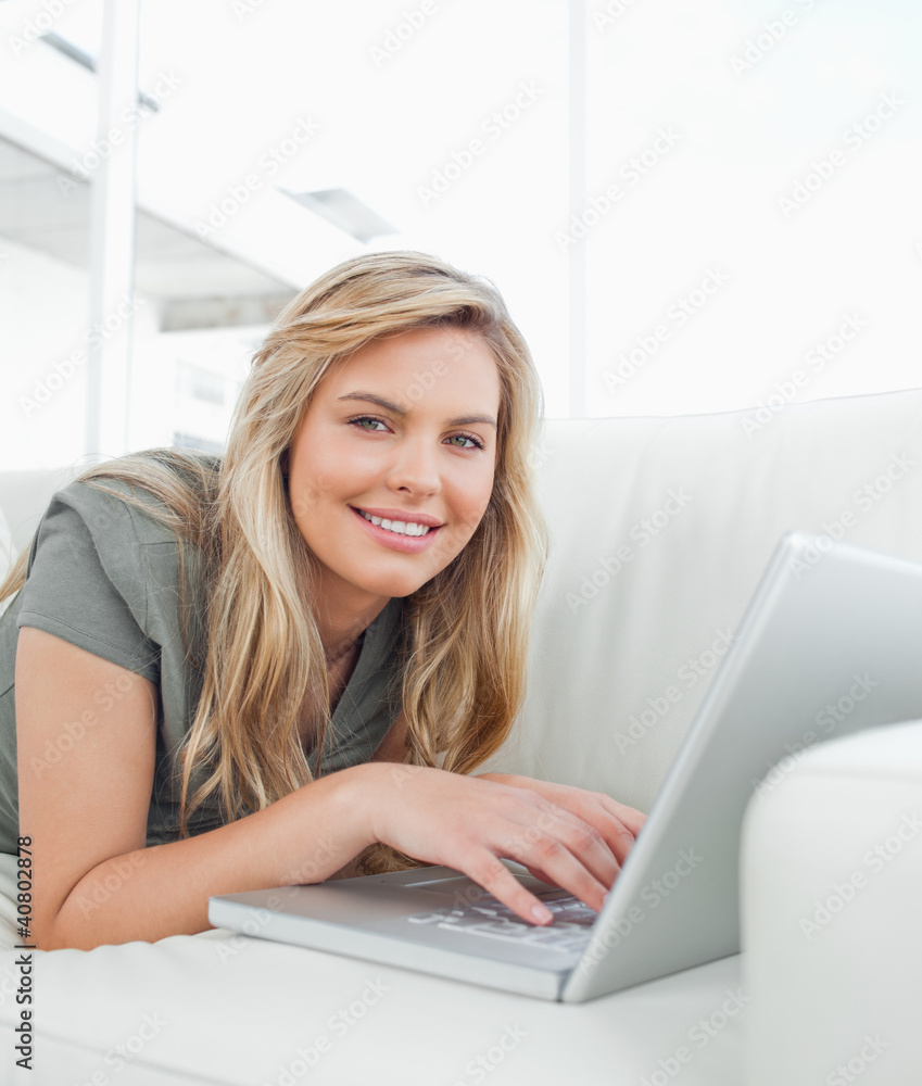 Woman looking forward,using her laptop and smiling Woman looking forward,using her laptop and smiling