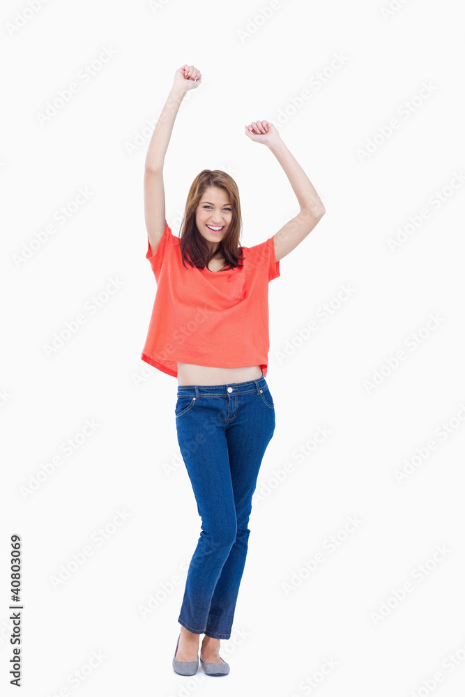 Laughing teenage wearing casual clothes while raising her arms Laughing teenage wearing casual clothes while raising her arms