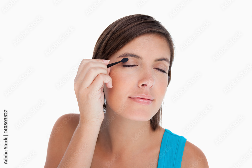 Teenager applying eyeshadow in a concentrated way Teenager applying eyeshadow in a concentrated way