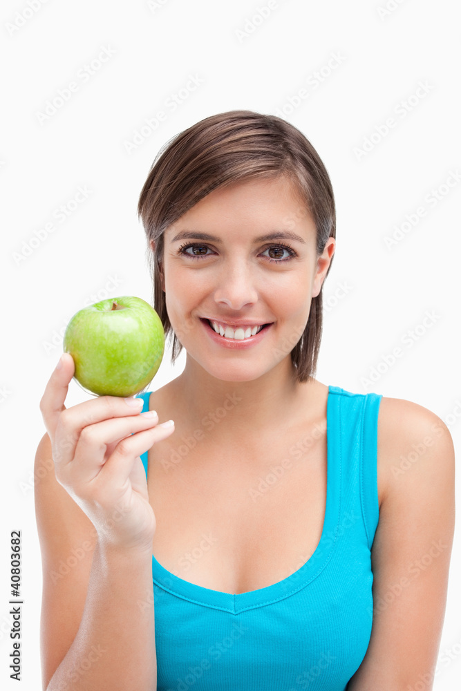 Young woman holding a green apple in her right hand Young woman holding a green apple in her right hand