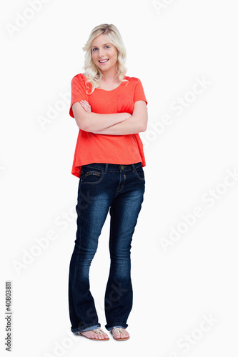 Smiling teenager crossing her arms while standing upright